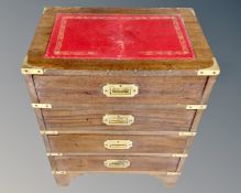 A ship's style four drawer chest with brass mounts and red leather inset panel