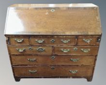 A George III fitted oak writing bureau with seven drawers