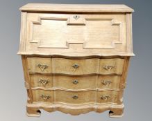 A 20th century Scandinavian blond oak serpentine fronted bureau with three drawers