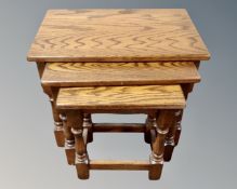 A nest of three oak tables and a magazine rack