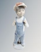 A Lladro china figure : Young Boy Wearing Denim Dungarees, height 22 cm.