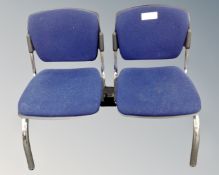 A metal framed triple section fixed seat upholstered in a blue fabric.