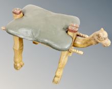 A camel stool with leather saddle