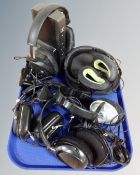 A pair of Sennheiser HDR175 cordless headphones on charging stand together with five further pairs