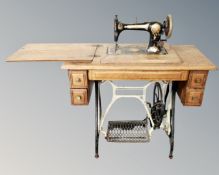 A 20th century Jones treadle sewing machine in oak table