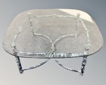 A contemporary glass topped coffee table on metal base