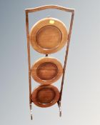 An Edwardian beech three tier folding cake stand