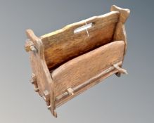 A rustic oak magazine rack of pegged construction