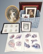 A wicker basket containing assorted pictures and prints,