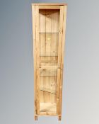 A contemporary pine and glass sentry door display cabinet with shelves