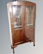 A 1930's oak double door glazed bookcase on raised legs 93 cm x 33 cm x 173 cm.