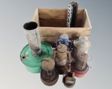 A vintage pine crate containing oil lamp, greenhouse heater,
