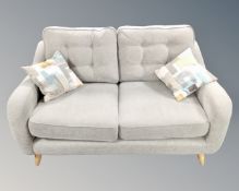 A Pamplona two seater sofa in natural grey fabric with two Etta mallow scatter cushions retailed by