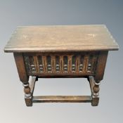 A carved oak storage stool containing CD's