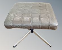 A mid-century footstool on steel base with leather top.