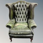 A Chesterfield wingback buttoned green leather armchair