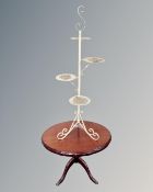 A reproduction oval pedestal occasional table on brass capped feet together with a wrought metal