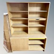 A continental light oak bookcase with cupboard sliding doors in base.
