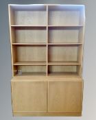 A light oak bookcase with cupboards in base.