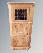 A continental light oak corner cabinet.
