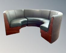 A three section half moon fixed seating plan upholstered in green vinyl.