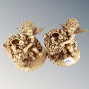 A pair of contemporary cherub candlesticks.