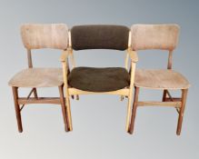 A 20th century light-oak armchair together with two plywood dining room chairs.