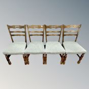 A set of four continental oak dining room chairs upholstered in green striped fabric.