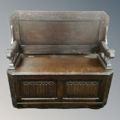 An early 20th century oak linen fold monk's bench