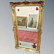 A mirror in ornate gilt frame, 54cm by 93cm.