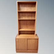 A 20th century Scandinavian teak sliding double door low cupboard together with similar open