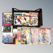 A basket containing Batman graphic novels and 20th century comics including Marvel and DC.