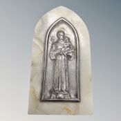 A white metal embossed religious icon mounted on marble.