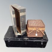 A vintage metal trunk together with a wicker basket and a wooden suitcase.