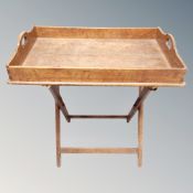 An Edwardian oak butlers tray on folding stand.