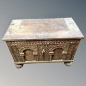 An early 19th century oak carved dowry chest on bun feet.