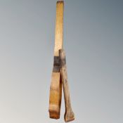 An antique wooden saddle clamp together with a further clamp.