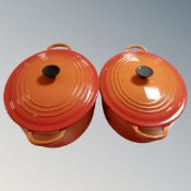 Two Le Creuset cast iron lidded casserole pans.