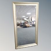 A contemporary 5' by 2' silvered framed bevel edged wall mirror.