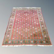 A Caucasian design rug with allover polychrome flower head motif on red ground,