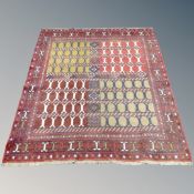 A Caucasian design rug with polychrome compartmentalised central field on red ground,