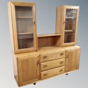 An Ercol Windsor elm and beech double door sideboard fitted with three central drawers