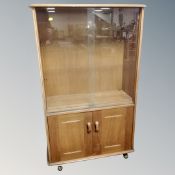 A vintage Ercol elm and beech double door sliding glass door bookcase