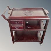 A Chinese hardwood three tier tea trolley fitted with two drawers and liftoff tray.