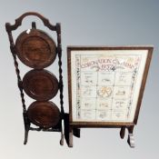 A 1937 Coronation calendar needlework fire screen in oak frame together with three tier folding