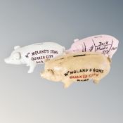 Three cast iron pig money boxes bearing advertisement.