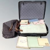 A Delsey hard shell luggage case containing vintage linens, together with a suit carrier.