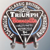 A cast iron Triumph three hook wall plaque.