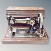 A vintage Singer hand sewing machine in case.