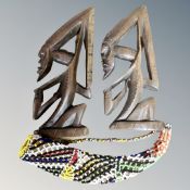 A pair of carved West African figures and a Guinea Koteka or phaldocrypt with bead decor